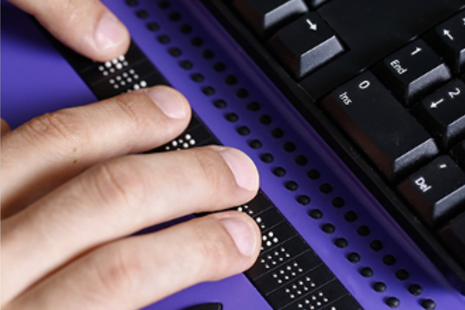 fingers touching braille on a keyboard